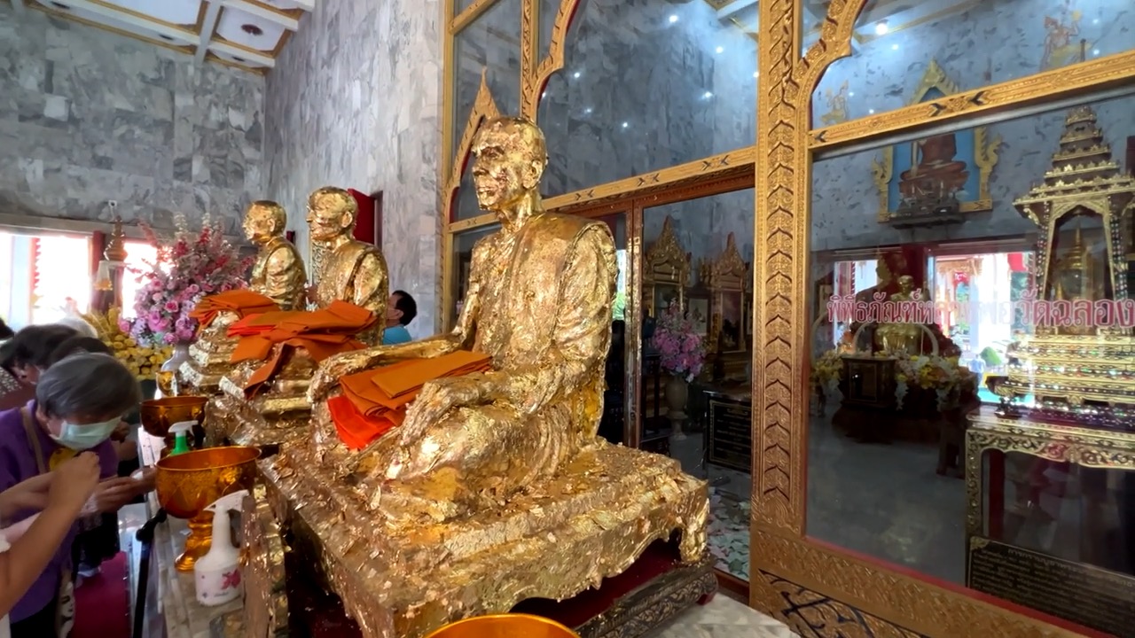 Trois statues de moines entièrement recouvertes de feuilles d'or