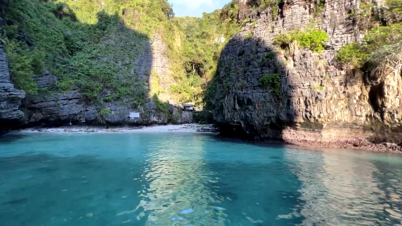 Une minuscule plage coincée entre deux falaises, eau turquoise
