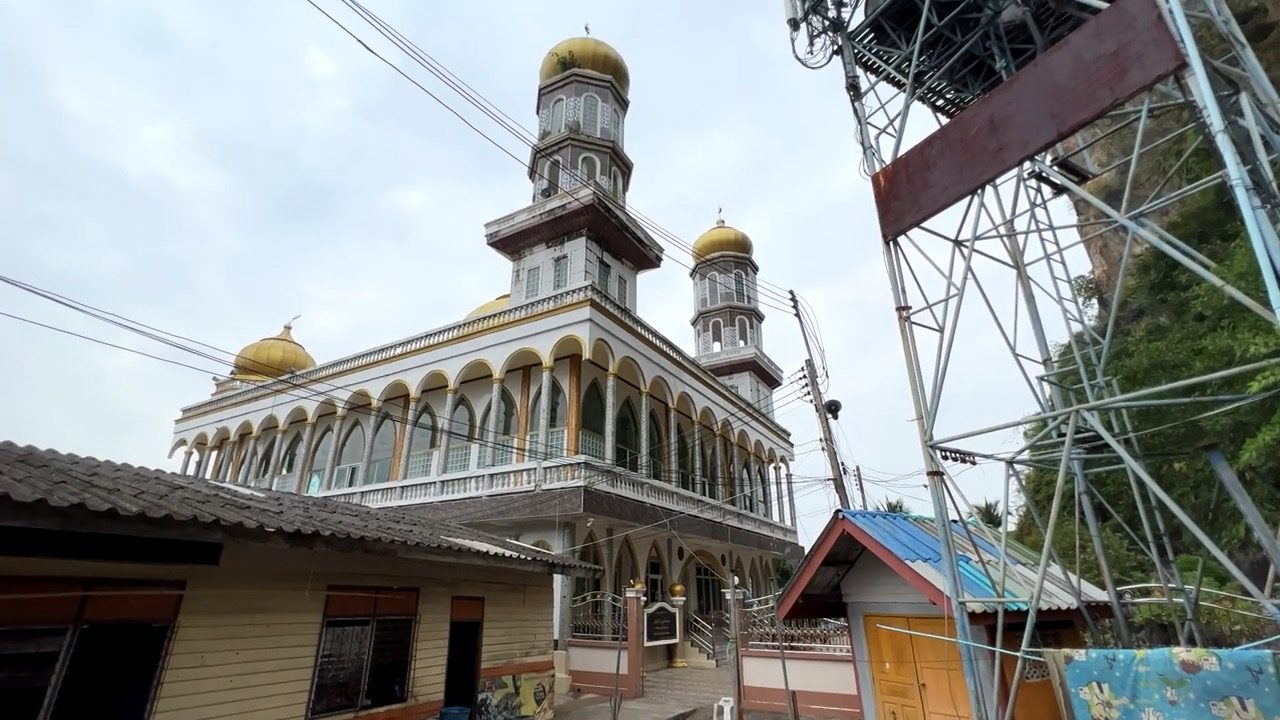 La mosquée de Panyee et ses dômes dorés, au pied de la falaise