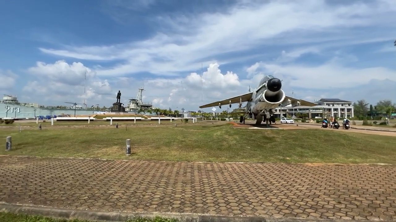Un avion de chasse exposé sur une pelouse devant le terminal de ferries de Klong Jilad, désert